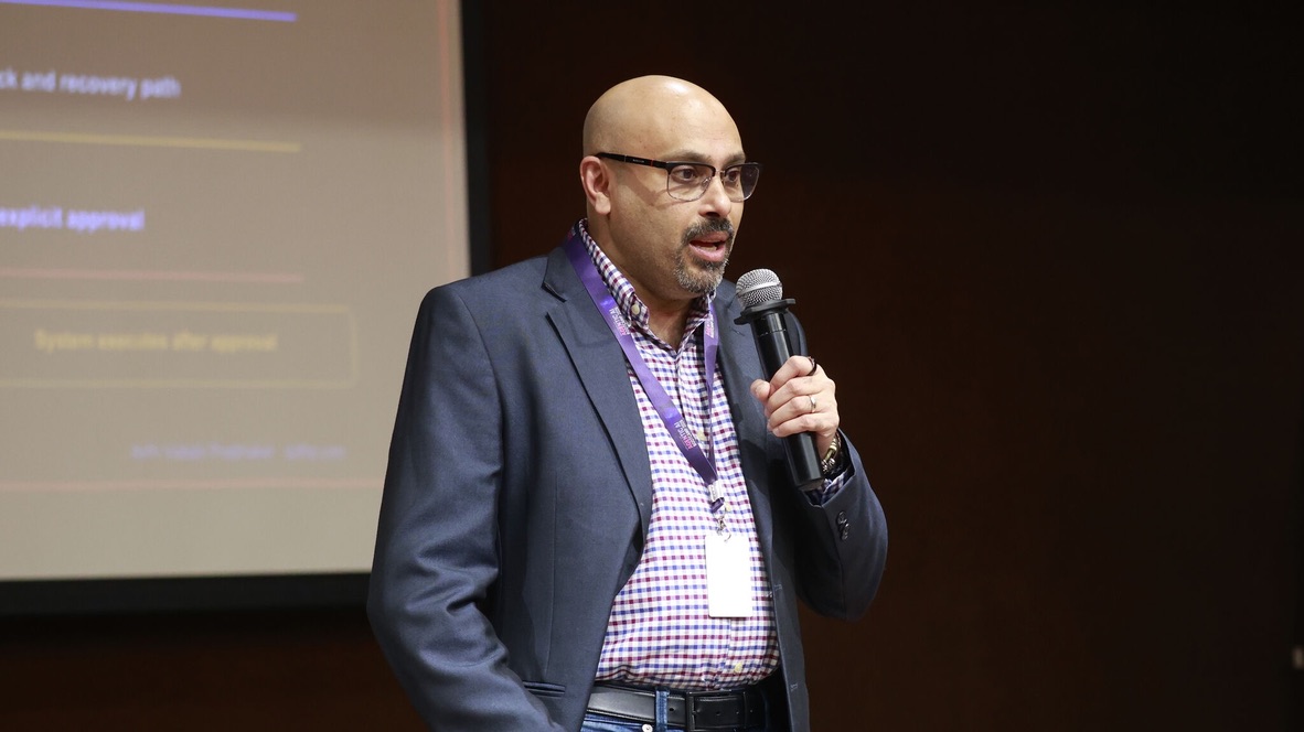 Ajith Vallath Prabhakar speaking into a handheld microphone.
